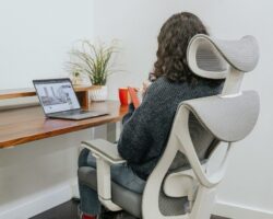 Person arbetar vid laptop i en ergonomisk kontorsstol