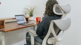 Person arbetar vid laptop i en ergonomisk kontorsstol